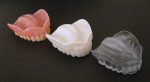 Figure 1. Photopolymerized print materials are available in a variety of shades and are shown here as printed denture reproductions in white and clear.