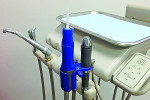 Figure 3 Aquasil Ultra Cordless digit power™ Dispenser (DENTSPLY Caulk). The Impression Dispenser, with installed intraoral tip, is shown in the blue plastic adapter. On the right is the regulator attached to the dental air line, and at the top of the regulator is
a silver knob with settings for fl ow rate of impression material.