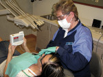 Figure 4  Patient holding the DIAGNOdent while a dental professional performs an examination.